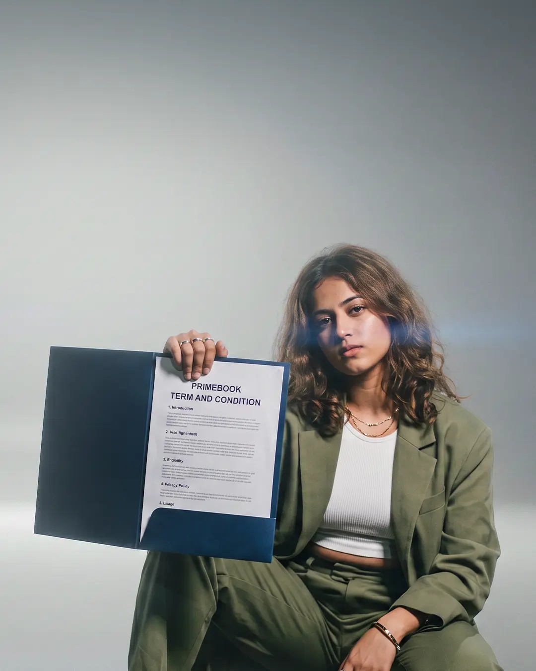 A woman on a city street at night holding an open folder showing the Primebook Terms and Conditions document